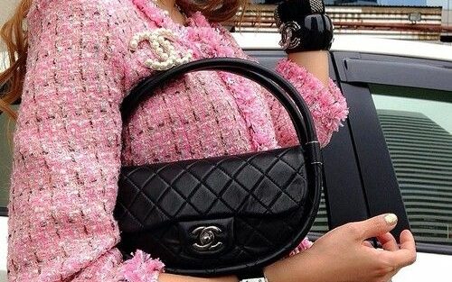 Fashionista combina blazer Chanel rosa com bolsa Chanel icônica preta.