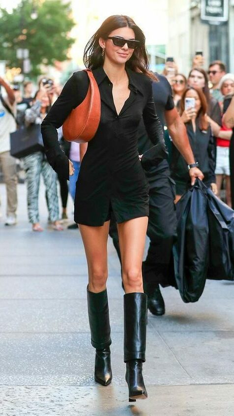 Kendall Jenner usando look inteiro preto e combinando com bolsa marrom.