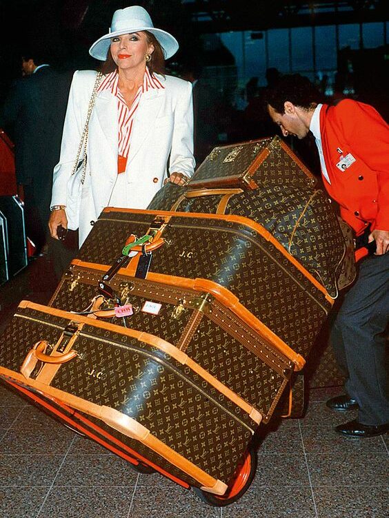 Joan Collins e suas malas Louis Vuitton.