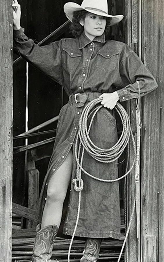Sally Marvel Freeman nos anos 80, usando uma camisa jeans longa, chapéu e botas de cowboy.